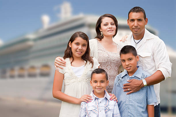 Young Happy Hispanic Family On The Dock In Front of a Cruise Ship.